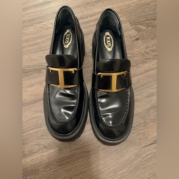 Tod's Shiny Black Loafers with Gold Accent